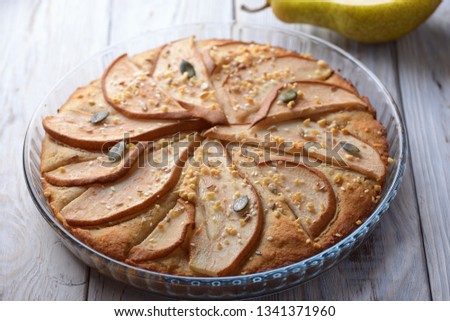 gorgeous pie with pears in a glass container on wooden background