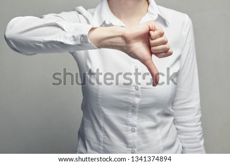 Business woman in white blouse showing gesture thumb down