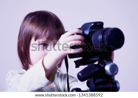  Little cute child girl photographer is taking a photo. Selective focus on eye.