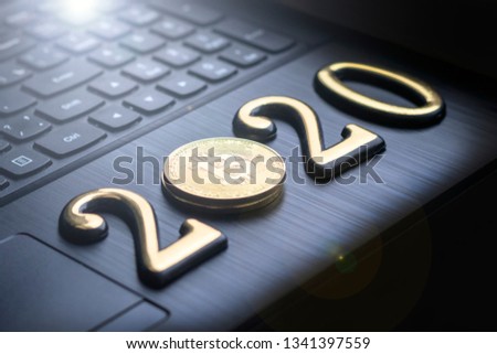 golden bitcoin lies on the keyboard of a dark colour. 