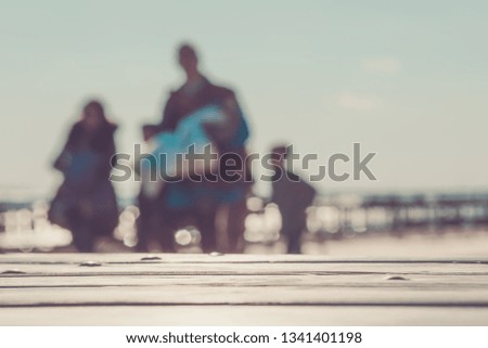 EMPTY WOODEN BACKDROP IN RETRO TONES WITH BLUR OF PEOPLE WALKING ON THE BEACH, LIFESTYLE BACKGROUND