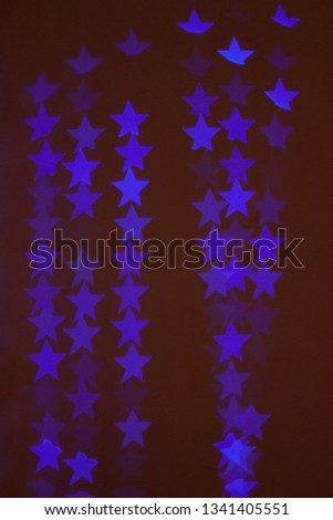 neon light of Christmas garlands in the form of stars on a dark background