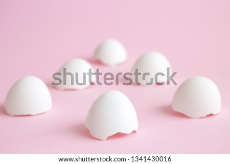 White egg shells against pastel pink background minimal creative easter concept.