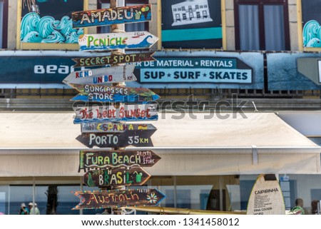 Group of colorful posters in a typical coastal town and surfer