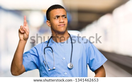 Surgeon doctor man with fingers crossing and wishing the best in a hospital