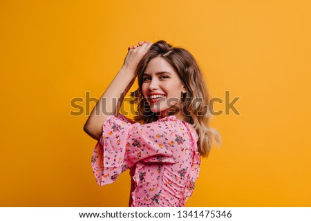 Laughing debonair caucasian girl looking to camera. Attractive female model expressing positive emotions on yellow background.