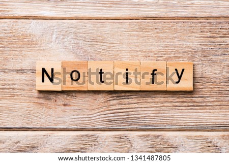 NOTIFY word written on wood block. NOTIFY text on wooden table for your desing, concept.