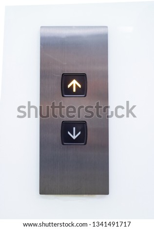 Elevator call button for building up and down each floor, push-button with arrow symbol displayed on polished stainless steel The keypad has an orange light displayed in the up position.