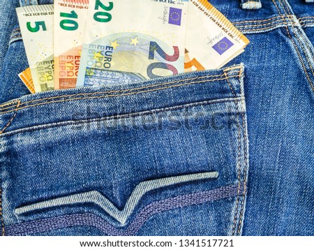 Euro Money notes in  blue denim jeans back pocket. Amount of money concept banner for web, giftcard, postcard. Concept of wealth, saving or spending money. Euro bills falling out. copy space, top view