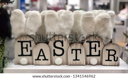 Decorative wooden Easter sign with white furry ears and cotton ball tails