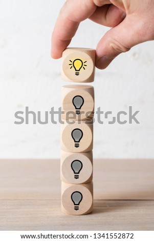 many people together having an idea symbolized by icons on cubes, stacked by a hand