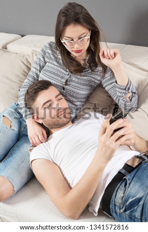 Young and married couple on sofa in apartment