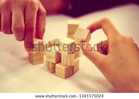 Close-up Of A Businesspeople Arranging Wooden Block On Office Desk business organization startup concept.
