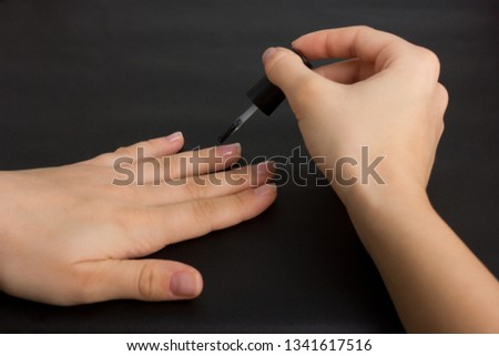 The hands of a young girl make a manicure with shellac coating and nail strengthening
