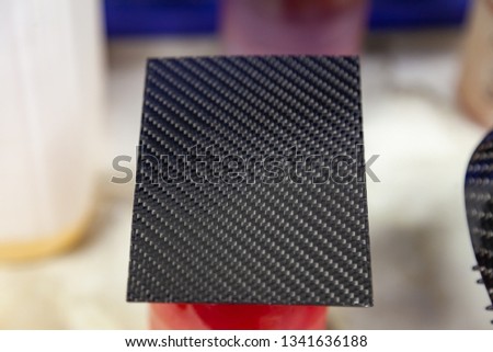 Carbon plate gray and black in the form of weaving from Kevlar, a very durable and lightweight modern material for the production of body element in the workshop for tuning and finishing interior part