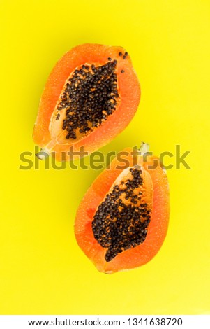 Top view of ripe half cut papaya on Illuminating Yellow color background. Healthy summer food concept with tropical fruits, flat lay
