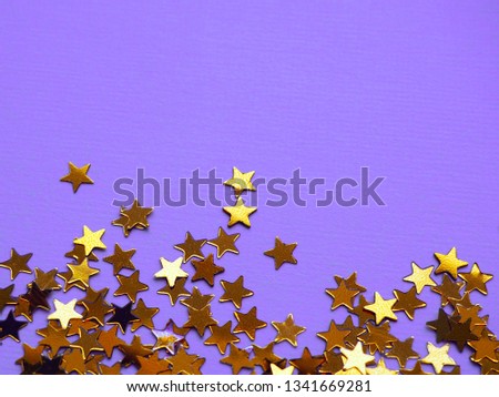 Golden stars glitter on violet background. Festive holiday bright backdrop