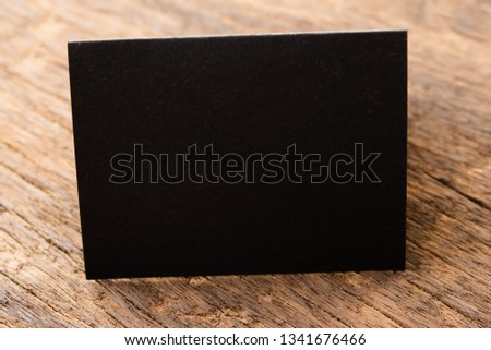 Blank portrait mock-up paper. brochure magazine isolated on brown wooden table, changeable background / Black paper isolated on wood