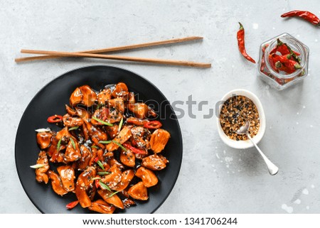 spicy chicken in sweet and sour sauce with chili pepper. teriyaki chicken's  with  sesame seeds. Chinese cuisine, copy space, recipe background, food flat lay, menu of japanese restaurant