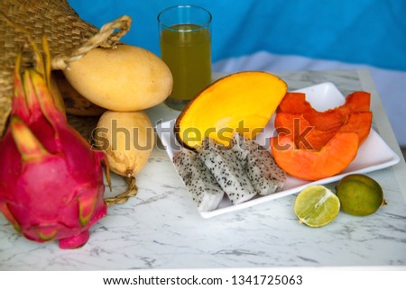  several different fruits such as mango, dragon, lime, papaya.