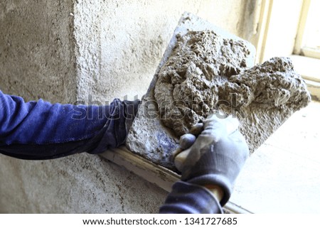 builder at work with his tools plastering a house stock photo