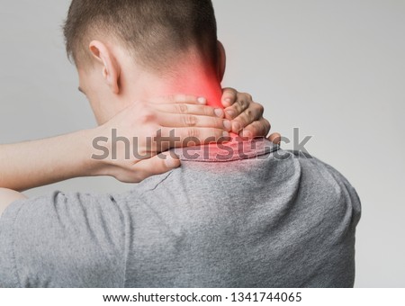 Man suffering from pain in neck. Symptom of cervical chondrosis. Inflammation of vertebra, back view Royalty-Free Stock Photo #1341744065