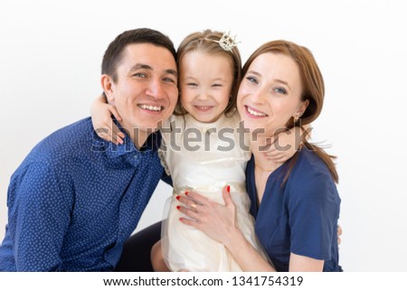 people, family and happiness concept - Mother and father with little daughter over white background