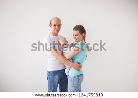 Parenthood, love and family concept - Smiling mother and father holding their baby daughter with copy space