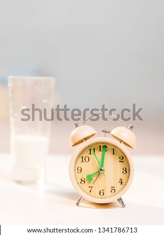 Milk and alarm clock on the table