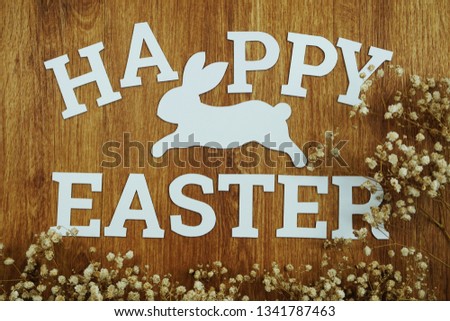 Happy Easter alphabet letters word with dried flower on wooden background