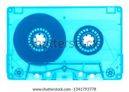 Trendy reviving retro magnetic audio cassette tape transparent neon blue isolated on white full frame. Analogue music hipster trend