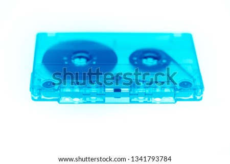 Trendy reviving retro audio cassette tape transparent neon blue isolated on white. Analogue music hipster trend