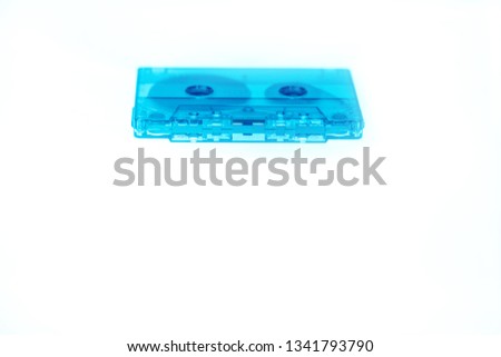 Trendy reviving retro audio cassette tape transparent neon blue isolated on white. Analogue music hipster trend