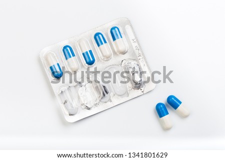 Blue and white capsules pill in blister pack . Global healthcare concept. Antibiotics drug resistance. Antimicrobial capsule pills. Pharmaceutical industry. - Image