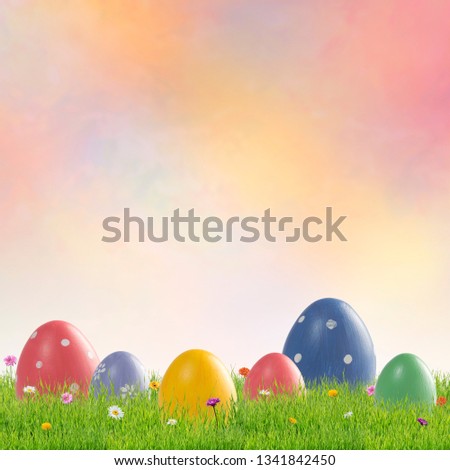 Holiday background with painted Easter eggs and flowers in green grass. Place for your text, copy space