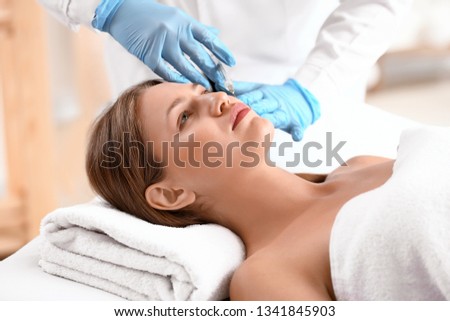 Young woman receiving injection in beauty salon Royalty-Free Stock Photo #1341845903