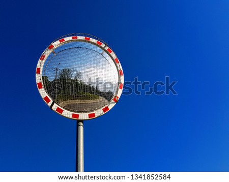 Road convex mirror on blue sky