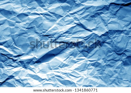 Crumpled sheet of paper in navy blue color. Abstract background and texture for design.