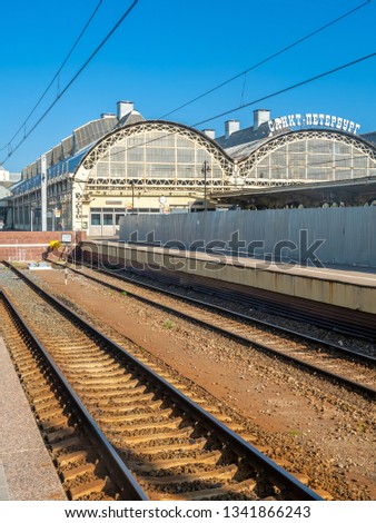 Saint Petersburg train station building with railway track on platform view under blue sky, Russia. Russian sign mean station name and Stop the car.
