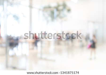 Abstract blur shopping mall and department store interior with people walking for background.