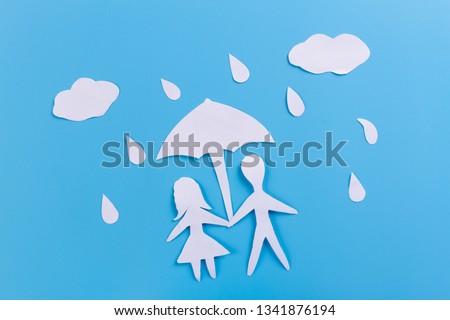 Silhouette of loving couple standing under an umbrella. paper cut