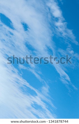 Blue sky and white clouds. Freshness of sky in early spring day. Bright blue background. Diagonal composition