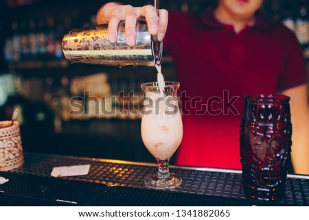 Bartender pouring using strainer Sweet juicy Cocktail drink on a bar counter . Bartender view . Trendy stylish edit . Copy paste for design people and luxury concept service barman in nightclub