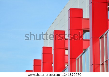 New office building in business center. Wall made of red steel and glass with blue sky. 