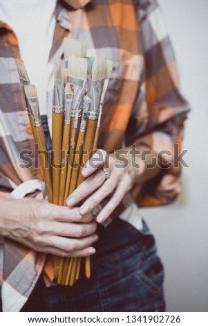 time of creativity. girl painter holds a brush
