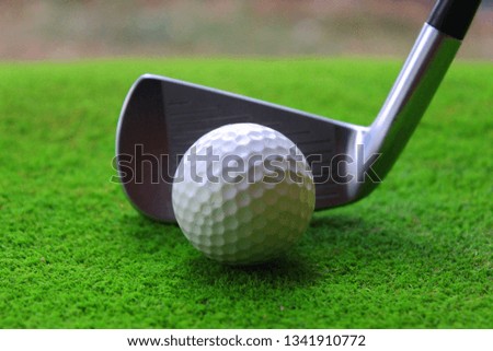 Golf balls and golf clubs on green green