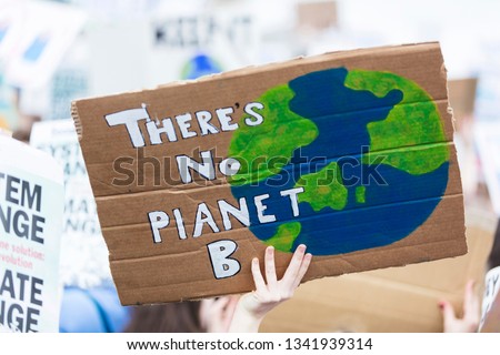 People with banners protest as part of a climate change march Royalty-Free Stock Photo #1341939314