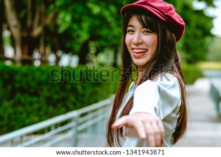 Portrait of young relaxing asian girl feeling freedom raised her hands in the air, Beautiful Smiling carefree Woman in the nature park with happy emotion. woman lifestyle, People freedom style.