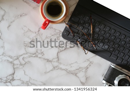 Mock up tablet with smart keyboard, vintage camera on marble workplace