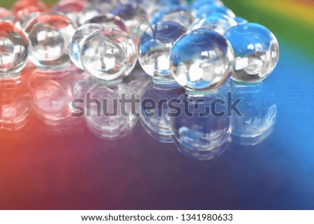 Water Gel Balls on the rainbow glass Background
